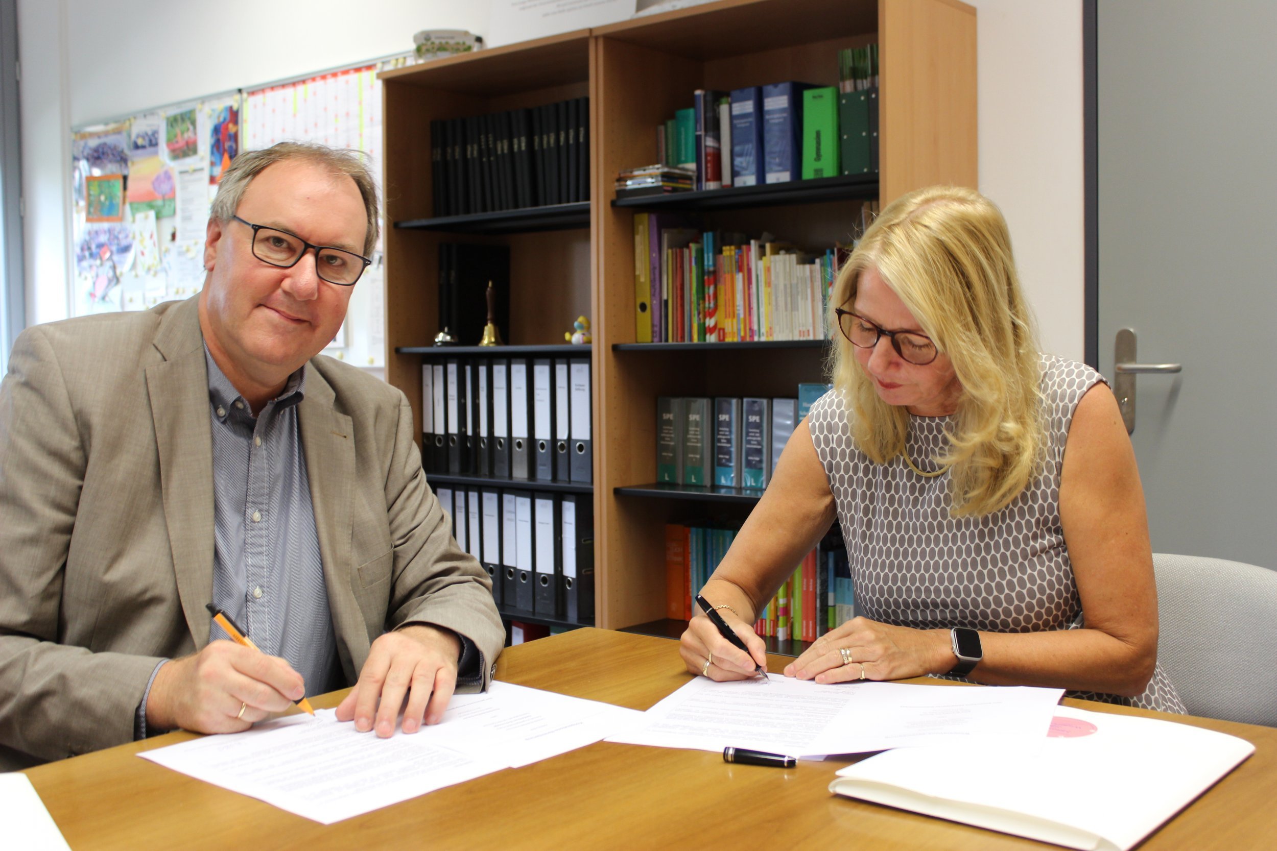 Frau Wullstein und Herr Dr. Binner unterschreiben den gemeinsamen Kooperationsvertrag