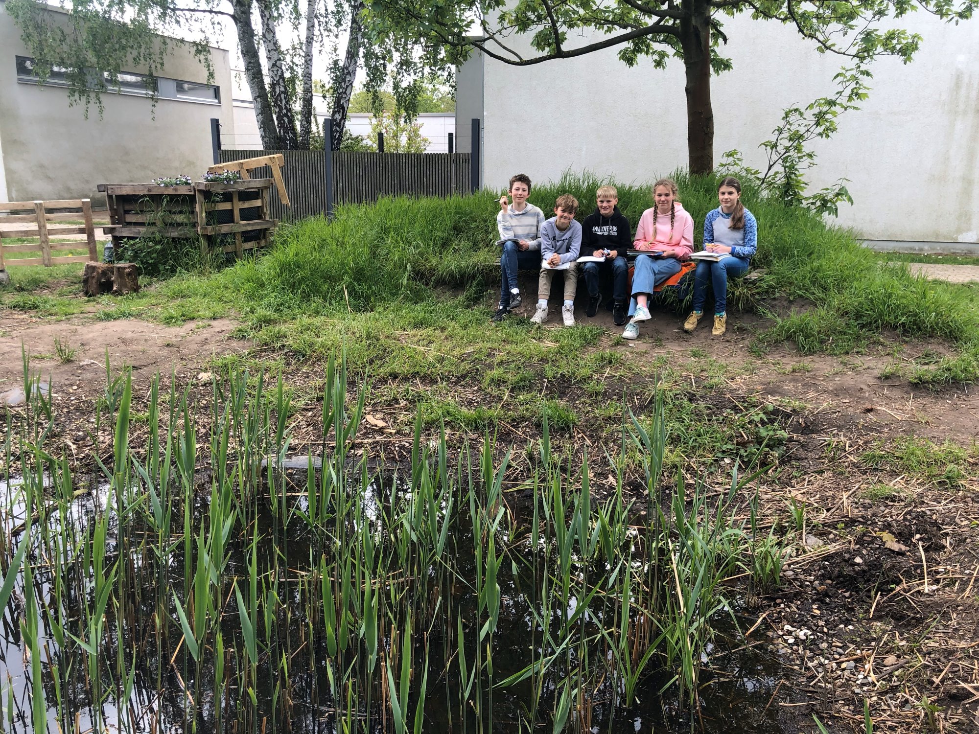 Schülerinnen und Schüler der Elsa sitzen am Teich